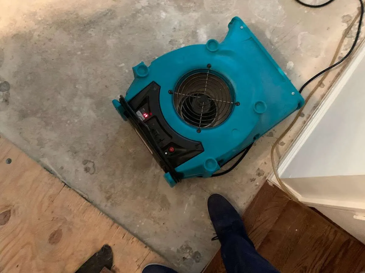 Air mover drying subfloor during Leak Detection & Repair in West Warwick